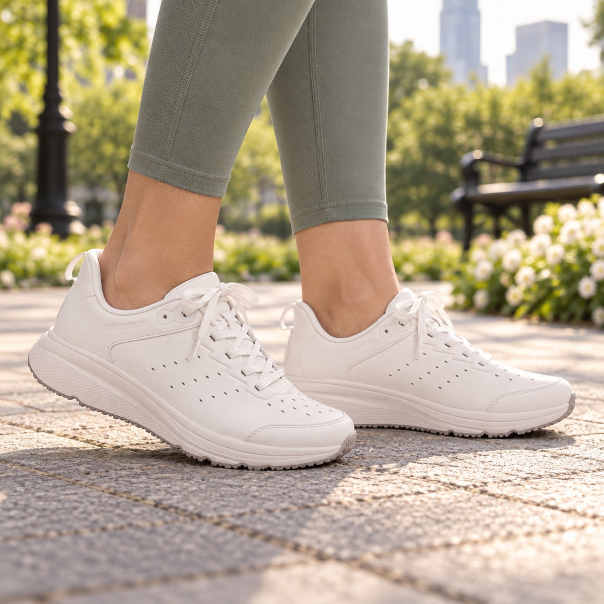 Illustrative lifestyle image: Revitalign Phoebe Pure White walking sneakers worn on a park path