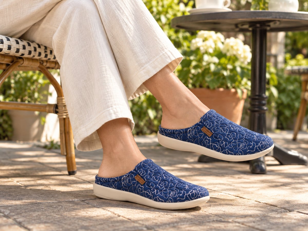 Illustrative lifestyle image: Revitalign Siesta Harmony Denim backless clogs worn at a garden patio